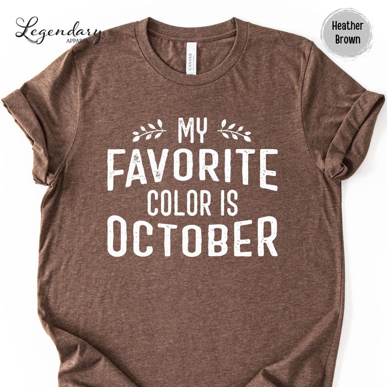 A brown t-shirt with the text "MY FAVORITE COLOR IS OCTOBER" printed on it.