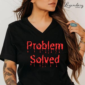 May include: Black V-neck t-shirt with the red text "Problem Solved" in a dripping font. The shirt is a casual style, suitable for everyday wear. The Legendary Apparel logo is visible in the upper right corner.