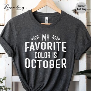A gray t-shirt with the text "My Favorite Color Is October" printed on it.