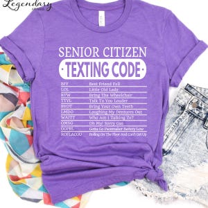 A purple t-shirt with a list of humorous texting codes printed on it, along with a denim skirt and a colorful scarf.