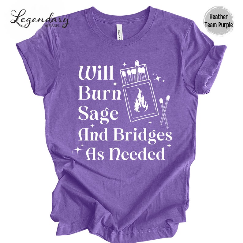 May include: Purple t-shirt with white text that reads "Will Burn Sage And Bridges As Needed". The text is accompanied by a graphic of a matchbox with matches and a flame.