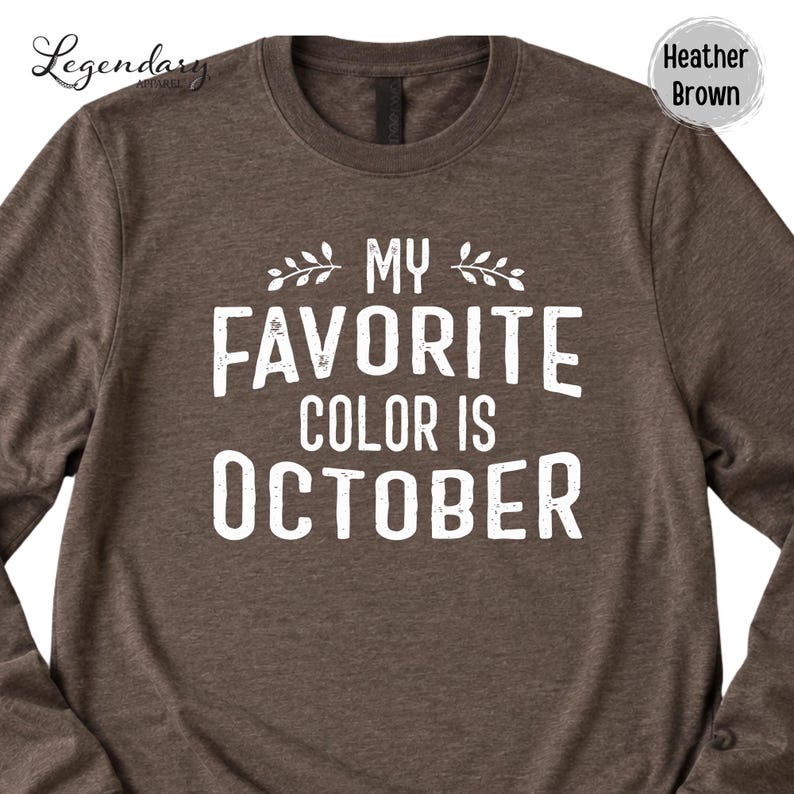 a brown long-sleeved t-shirt with a white text design printed on it. The text reads "My favorite color is October".
