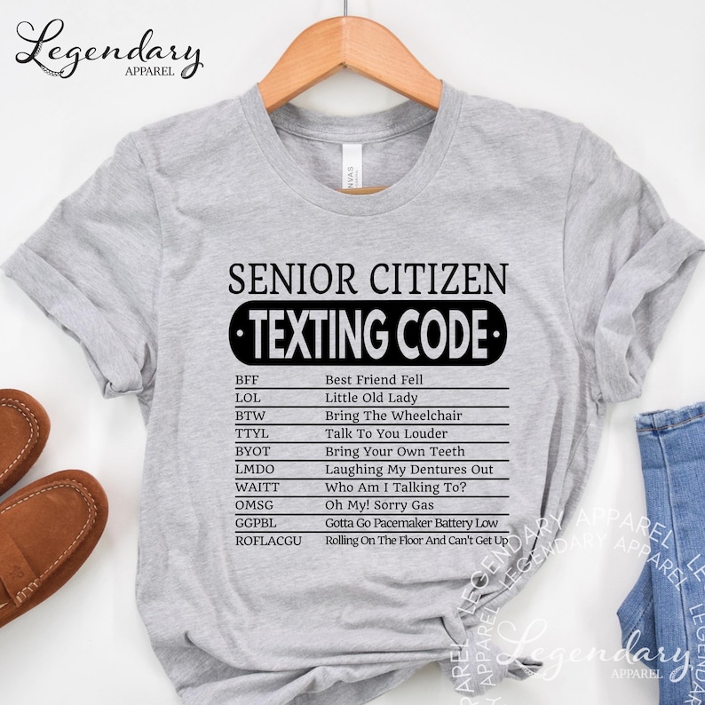 A gray t-shirt with a humorous list of "senior citizen texting code" written in black text.
