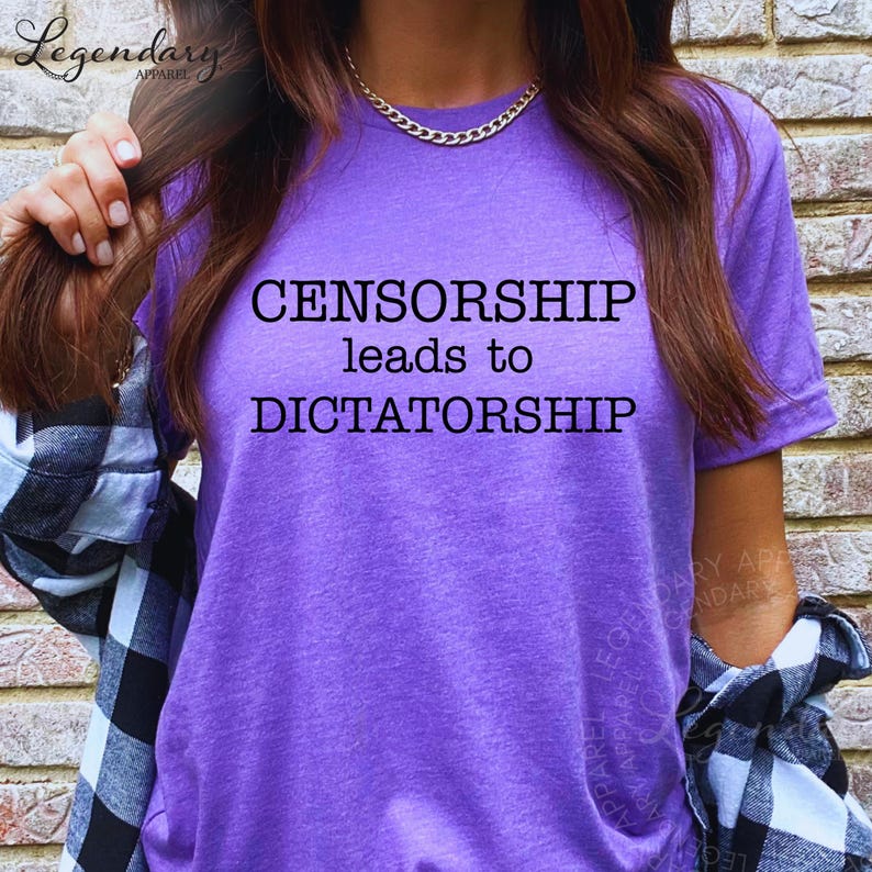 A person wearing a purple t-shirt with the text "CENSORSHIP LEADS TO DICTATORSHIP" printed on it.