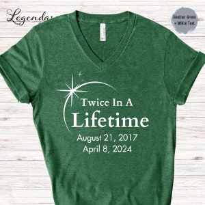 May include: Heather green v-neck t-shirt with white text that reads "Twice In A Lifetime" and the dates "August 21, 2017" and "April 8, 2024".