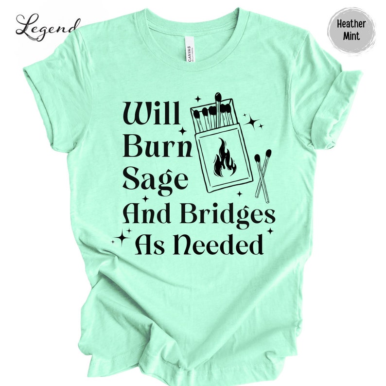 May include: A light green t-shirt with the text "Will Burn Sage And Bridges As Needed" in black. The text is accompanied by a graphic of a box of matches with a flame and two crossed matches.