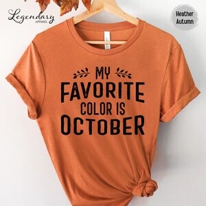a bright orange t-shirt with the text "My favorite color is October" printed on it.