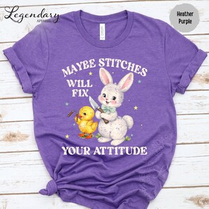 The image is a purple t-shirt with a cartoon rabbit and a yellow duck, along with the text "MAYBE STITCHS WILL FIX YOUR ATTITUDE" printed on it.