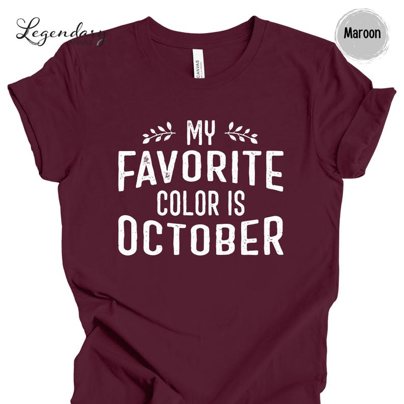 The image is a maroon t-shirt with the text "MY FAVORITE COLOR IS OCTOBER" printed on it.