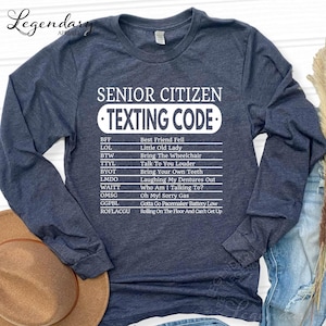 A gray long-sleeved t-shirt with a humorous text list printed on it, which appears to be a " Senior Citizen Texting Code" or a list of rules for senior citizens to follow when texting.