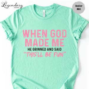 A mint green t-shirt with a humorous text printed on it.