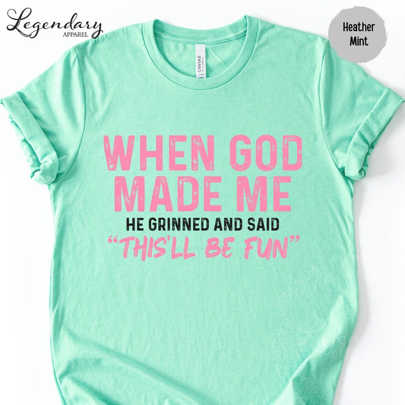 A mint green t-shirt with a humorous text printed on it.