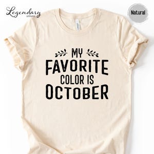 a beige t-shirt with a black text design that reads "My favorite color is October".