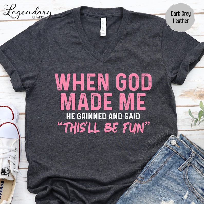 A black t-shirt with a humorous text printed on it, along with a pair of jeans and a pair of sneakers.