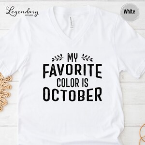 A white t-shirt with the text "MY FAVORITE COLOR IS OCTOBER" printed on it.