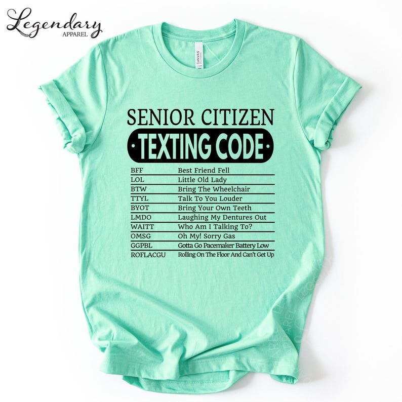 A mint green t-shirt with a humorous text that reads "SENIOR CITIZEN TEXTING CODE" printed on it.