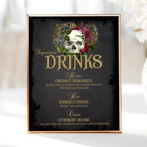 May include: A black chalkboard sign with gold lettering and a skull with flowers. The sign reads "Signature Drinks" and lists three drinks: "Hers: Coconut Margarita", "His: Whiskey Ginger", and "Ours: Starlight Royale".