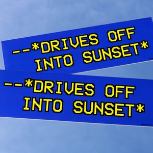 May include: Two rectangular blue stickers with yellow pixelated text. The text reads "--*DRIVES OFF INTO SUNSET*" in a retro computer font. The stickers are displayed against a light blue background.