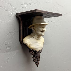 Puede incluir: Un letrero de madera rústico con el texto "Welcome to our home" en letras blancas. El letrero presenta un acabado envejecido y un diseño simple y acogedor, ideal para la decoración de la puerta principal.