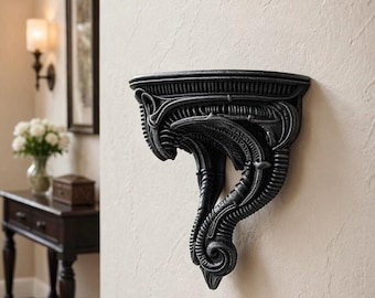 Könnte beinhalten: Schwarzes Wandregal mit einem komplizierten, organischen Design. Das Regal hat eine gebogene Oberseite und eine detaillierte, strukturierte Tragstruktur. Das Design weist fließende Linien und eine dunkle, matte Oberfläche auf, montiert an einer hellen Wand.
