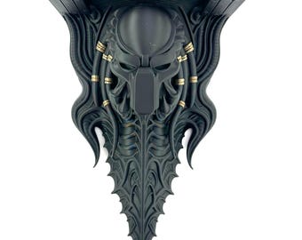 May include: A matte black wall-mounted shelf featuring a sculpted Predator creature mask as the central support bracket. The design includes intricate organic detailing, flowing lines, and small metallic gold-colored accents along the sides.