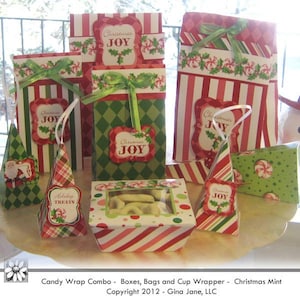 Op de afbeelding: Een set kerstthema cadeaudozen, tassen en een bekerverpakking. De dozen en tassen zijn versierd met rode en groene strepen, snoepstokken en de woorden "Christmas Joy". De bekerverpakking is versierd met een groen-wit patroon en een rood-wit gestreept patroon.