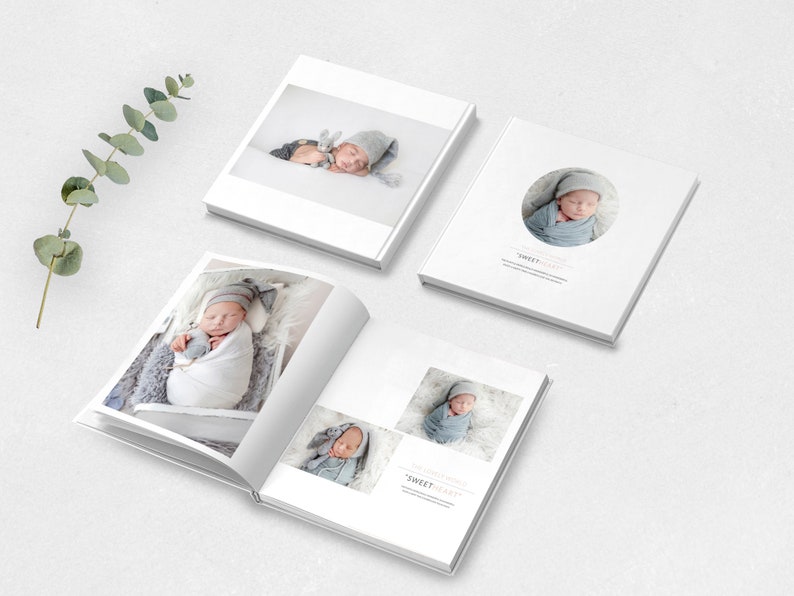 May include: A white photo album with a baby in a white blanket and a gray hat. The album has a circle on the cover with the text "Sweet Dreams" inside.