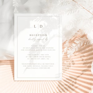 May include: A white wedding reception invitation with the initials "LD" in a simple, elegant font. The invitation includes the text "Reception kindly respond by" and details about the event, including the time, location, and transportation information. The invitation is set against a background of white and beige.