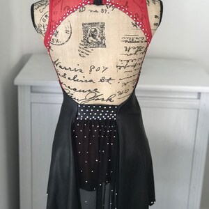 May include: Black and red dance costume with a sheer skirt and rhinestones. The costume has a low back with a cutout and a black belt.