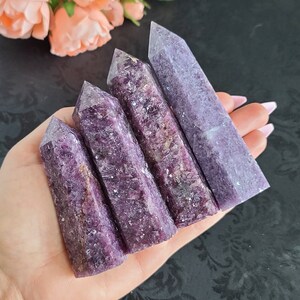 May include: Five purple lepidolite crystal points of varying sizes, arranged in a fan shape, with the largest point at the top and the smallest point at the bottom.