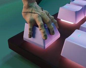 May include: A close-up of a hand with stitched seams pressing a purple keyboard key. The keyboard has a dark gray base and other purple keys.