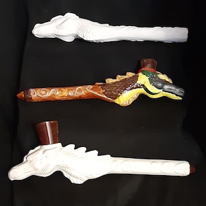 May include: Three ceramic dragon pipes, one with a brown and gold dragon design, one with a white dragon design, and one with a white dragon design with a brown top.