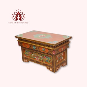 May include: A hand-painted wooden table with intricate floral and dragon designs in shades of orange, gold, blue, and green. The table has a flat top and four legs with decorative carvings.