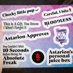 May include: A set of 8 colorful stickers with various text and images. The stickers feature phrases like "Cheeky little pup", "Careful, I bite", "This is a gift, you know. I won't forget it", "Astarion approves", "You couldn't wait 10 seconds before being an absolute freak", "Bloodless", "Chaotic Quest", and "Astarion's personal juice box".