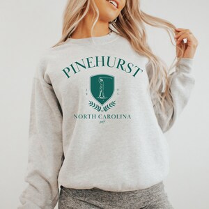 May include: Gray sweatshirt with a green graphic of a golfer and the text "Pinehurst 1895 North Carolina golf"