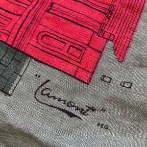 May include: A gray fabric tote bag with a red and black illustration of a building. The text "Lamont" is written in black cursive with the word "REG" below it.