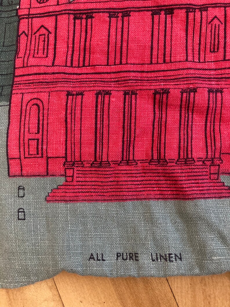 May include: A red and gray linen fabric with a black and white illustration of a building with columns. The fabric has the text "ALL PURE LINEN" printed on it.