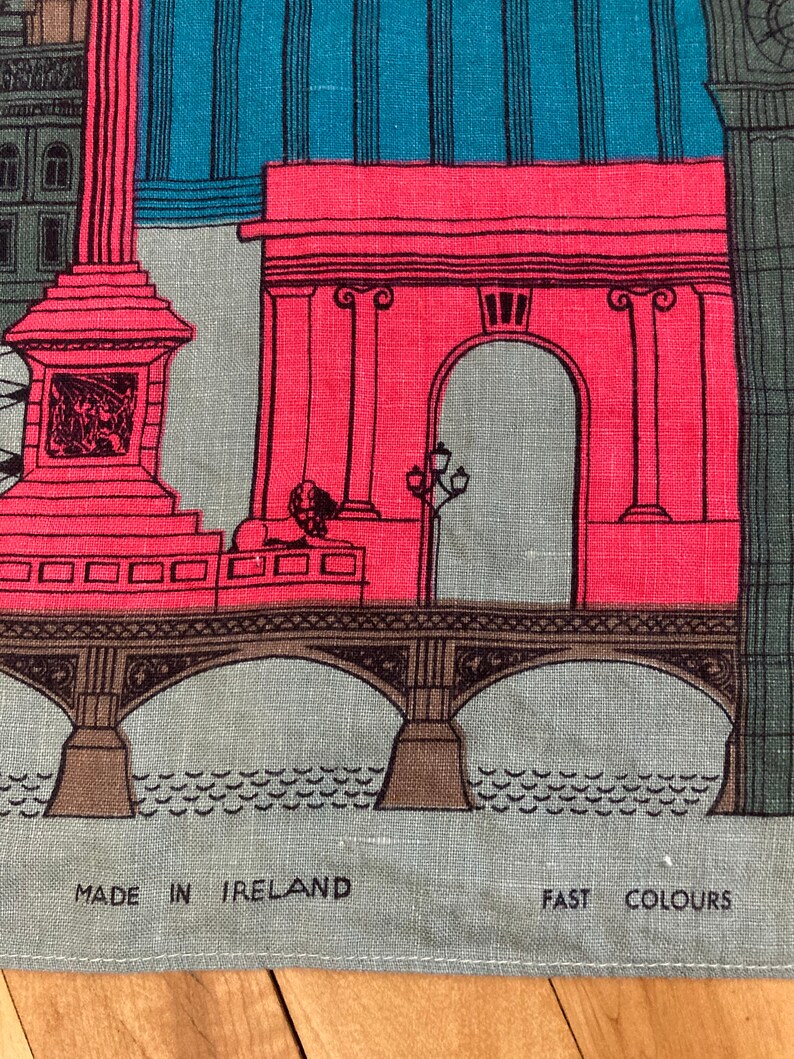May include: A colorful illustration of a bridge with an archway and a building with a column. The image is printed on a gray linen fabric with the text "MADE IN IRELAND" and "FAST COLOURS" at the bottom.