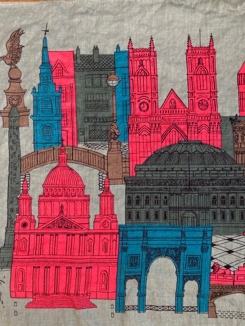 May include: A vintage linen tea towel featuring a colorful illustration of London landmarks, including Big Ben, St. Paul's Cathedral, and the Tower Bridge. The design is in shades of red, blue, and green.