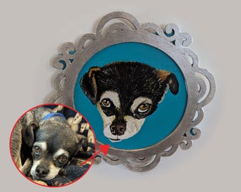 May include: A framed portrait of a small dog with a black and brown coat, set against a teal background. The ornate silver frame adds a decorative touch. A smaller inset image shows the dog.