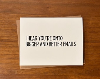 May include: A white rectangular greeting card with black text that reads I HEAR YOU'RE ONTO BIGGER AND BETTER EMAILS, layered on top of a brown kraft paper envelope. The card features a clean, simple design with bold, sans-serif typography.