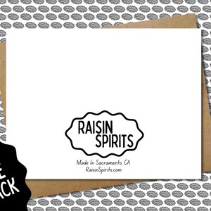Pu&ograve; includere: Il retro di un biglietto di auguri bianco con la scritta "RAISIN SPIRITS" in una forma di nuvola nera con bordi ondulati. Sotto il logo c'&egrave; "Made In Sacramento, CA RaisinSpirits.com". Il biglietto &egrave; su una busta marrone, con uno sfondo a motivi grigi.