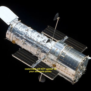 May include: A silver and black space telescope with solar panels and a large, cylindrical main body. The telescope is in orbit against a black background.