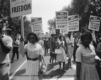 May include: Black and white photo of a civil rights march. People are holding signs that read "We Demand Equal Rights Now!" and "We March for Integrated Schools Now!"