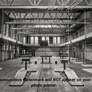 May include: Black and white photograph of a vintage gymnasium. The image shows pommel horses, rings, and other gymnastics equipment. The room has large windows and a high ceiling with exposed beams. The text "-famousdocs watermark will NOT appear on your photo poster-" is at the bottom.