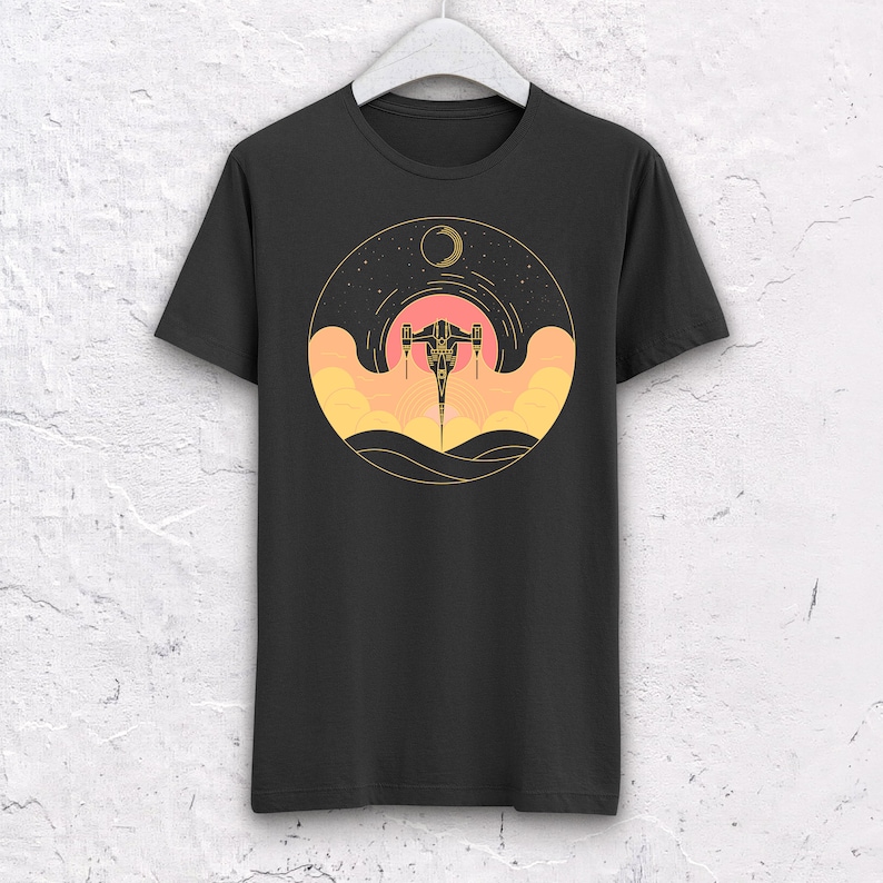 May include: Black t-shirt with a graphic of a spaceship flying through a sunset with a crescent moon in the background.