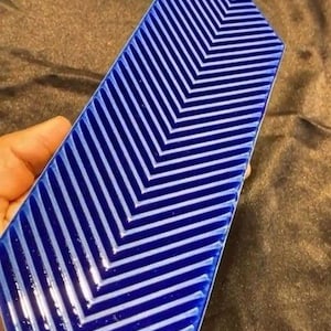 May include: A blue and white chevron patterned tile with the text "VISTA TILES TRUE TERRAZZO" at the top.
