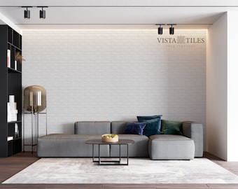 May include: A gray sectional sofa with blue and green throw pillows sits in front of a white brick wall. The room has a modern design with track lighting and a black bookshelf.