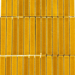 Op de afbeelding: Een vel gele keramische mozaïektegels. Elke tegel is een lange, dunne rechthoek met een glanzende afwerking. De tegels zijn gerangschikt in rijen en kolommen.