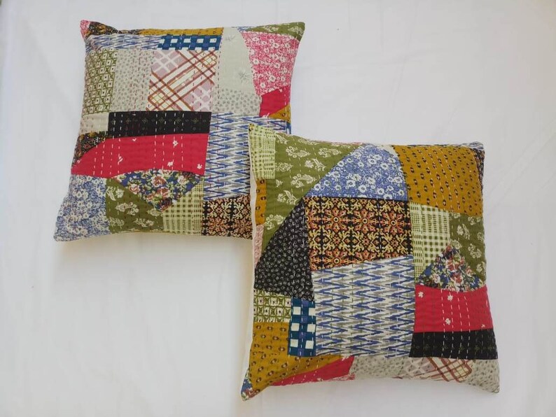 May include: Two square patchwork throw pillows with a variety of colorful fabrics and patterns. The pillows are made of cotton and have a quilted design.